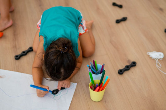 niña jugando con juego de construcción y pintando