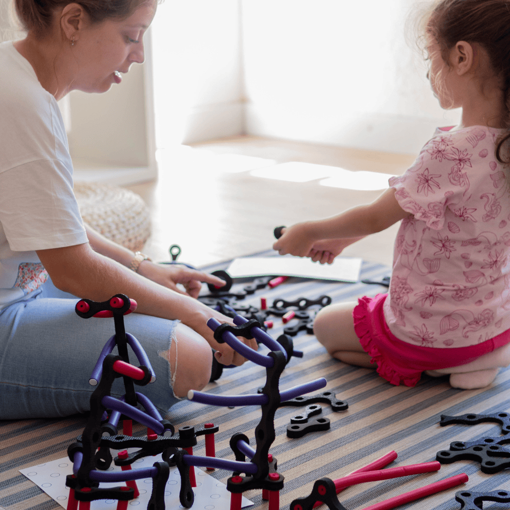Familia jugando con el juego de construcción de criaturas infinitas